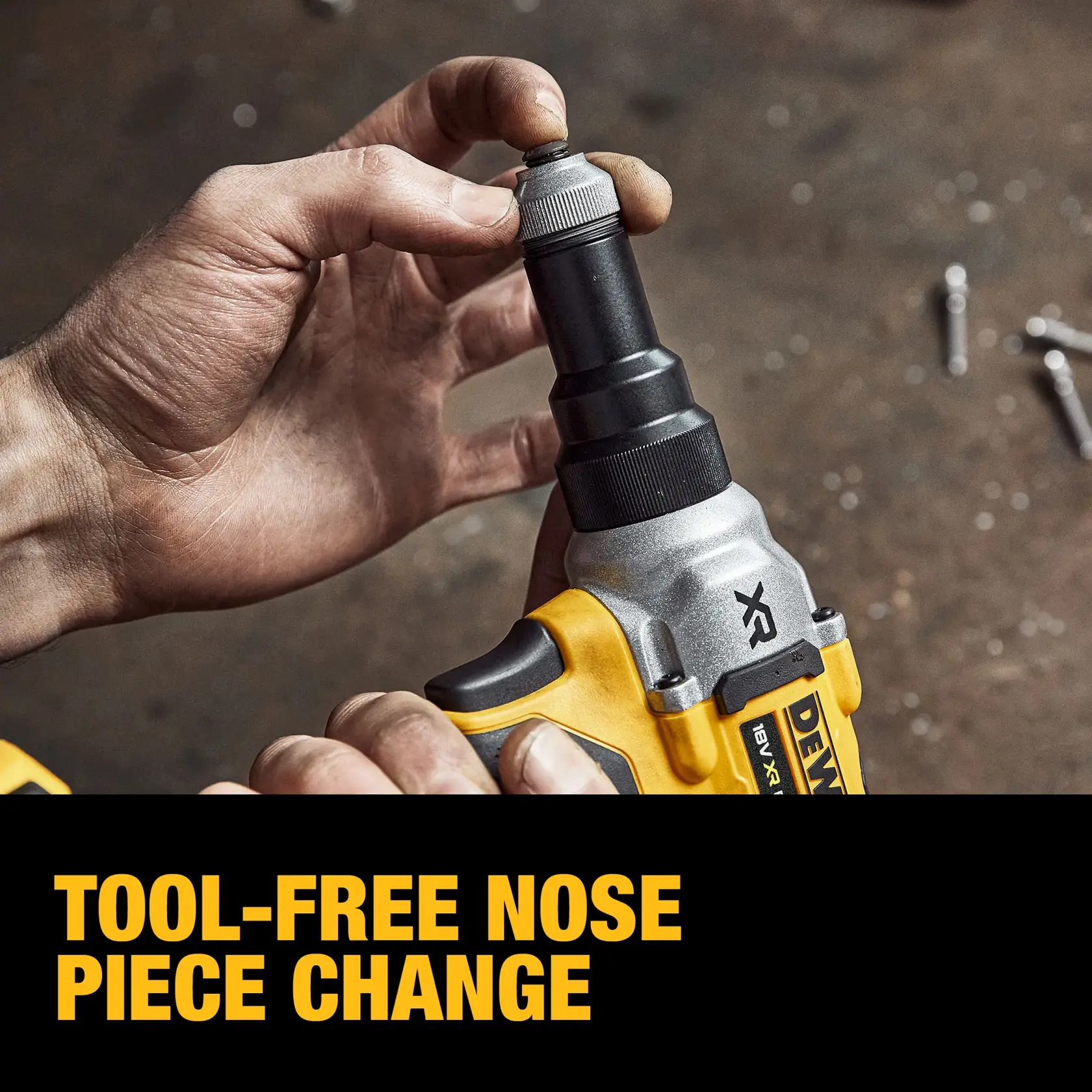 Una persona con guante negro usa una herramienta eléctrica DEWALT DCF414E2GT amarilla y negra para perforar o fijar una señal de tráfico en un banco de trabajo metálico en un taller industrial.