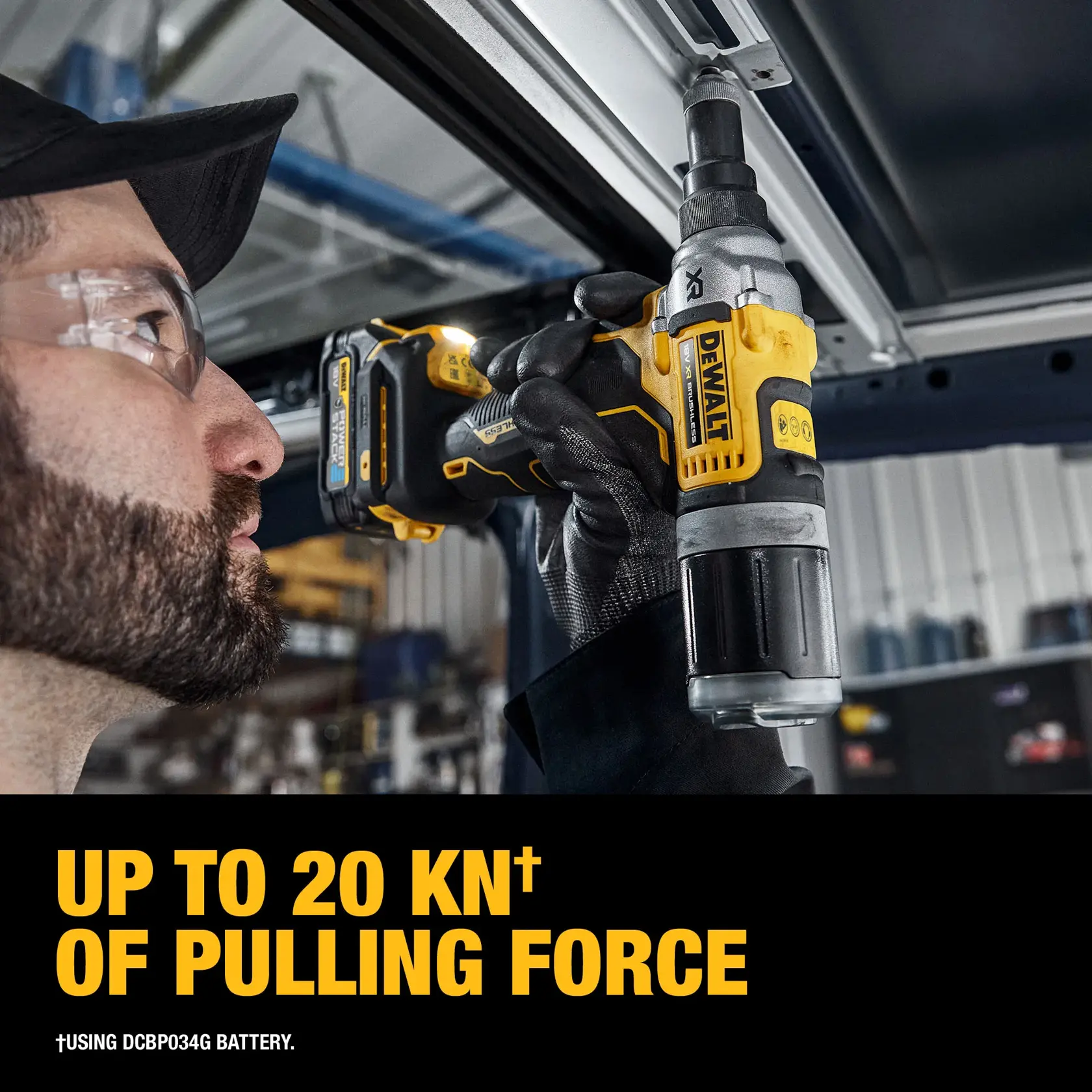 Una persona con equipo de seguridad utiliza una herramienta eléctrica DEWALT DCF414E2GT para perforar una caja metálica grande en un entorno industrial. Se pueden ver otras herramientas DEWALT y tornillos en la mesa de trabajo.