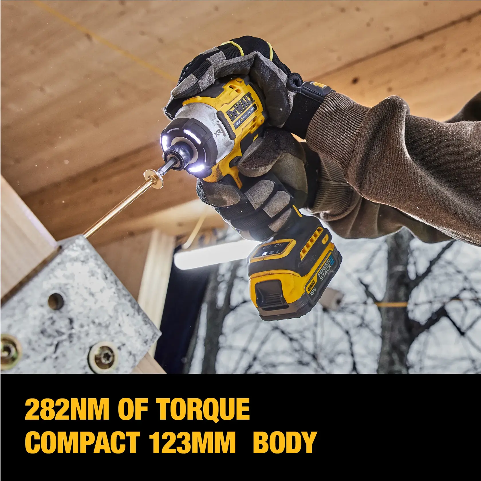 Worker uses DEWALT impact driver DCF860E2T on metal outdoors, wearing safety gear and gloves.