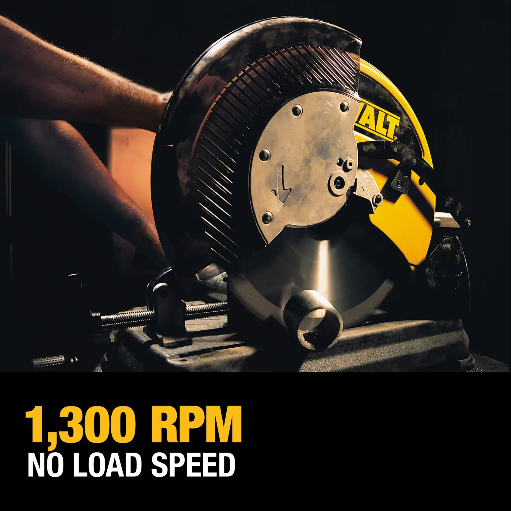 Una sierra de corte de metal DEWALT en uso, con una hoja circular grande cortando una tubería de metal. El fondo es oscuro y la máquina es amarilla con el logotipo DEWALT. El texto arriba dice 'Velocidad sin carga de 1300 RPM' en español.