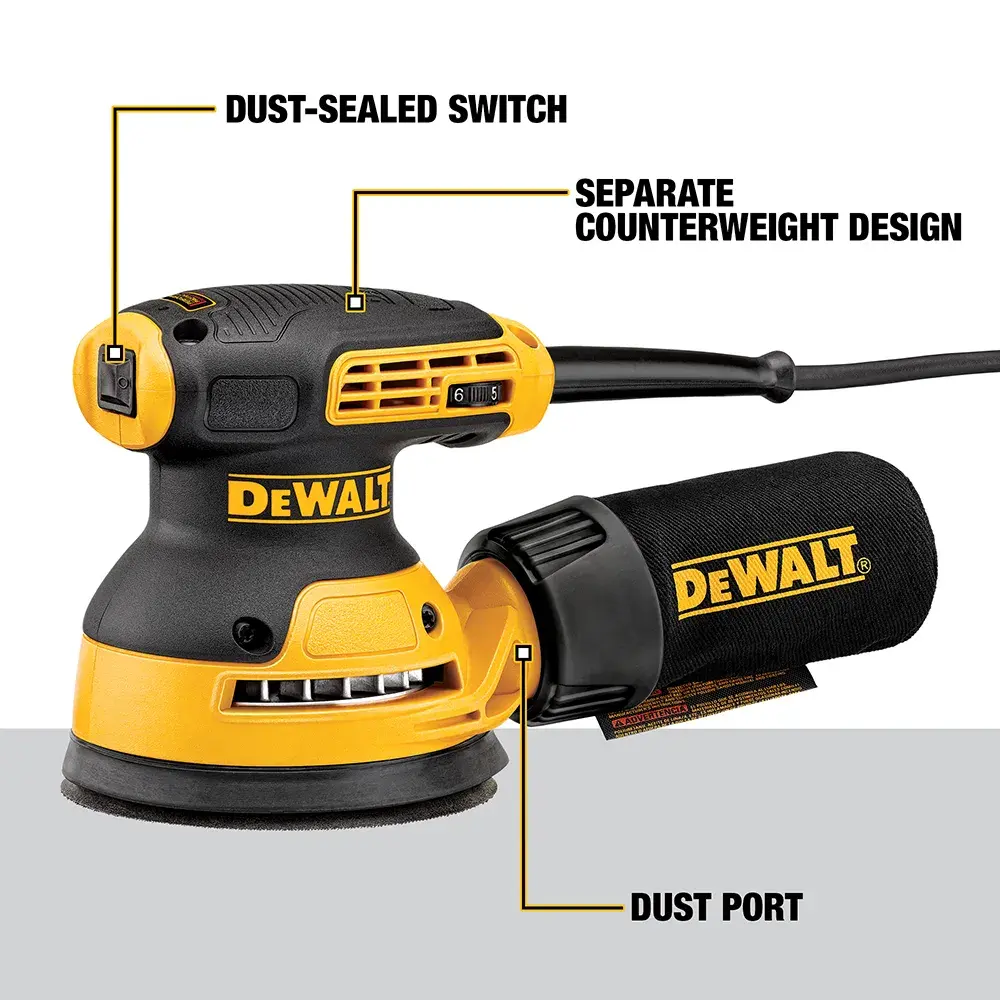 Una persona utiliza una lijadora orbital aleatoria DEWALT DWE6423 para suavizar una superficie de madera grande en un taller. El rostro de la persona está difuminado por privacidad. Hay herramientas de carpintería y piezas de gabinete visibles en la mesa de trabajo.