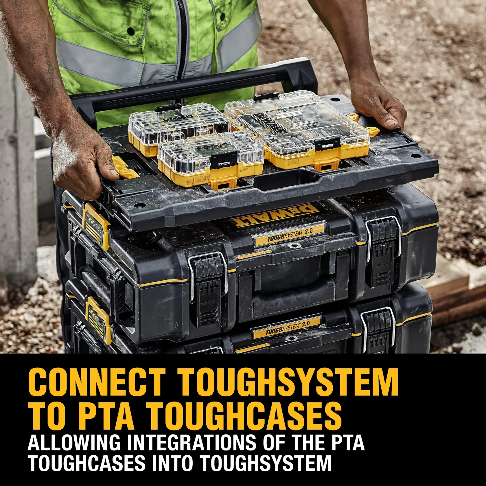 A person wearing a green safety vest is handling a stack of black and yellow DEWALT ToughSystem 2.0 toolboxes outdoors, with focus on the top box being carried.
