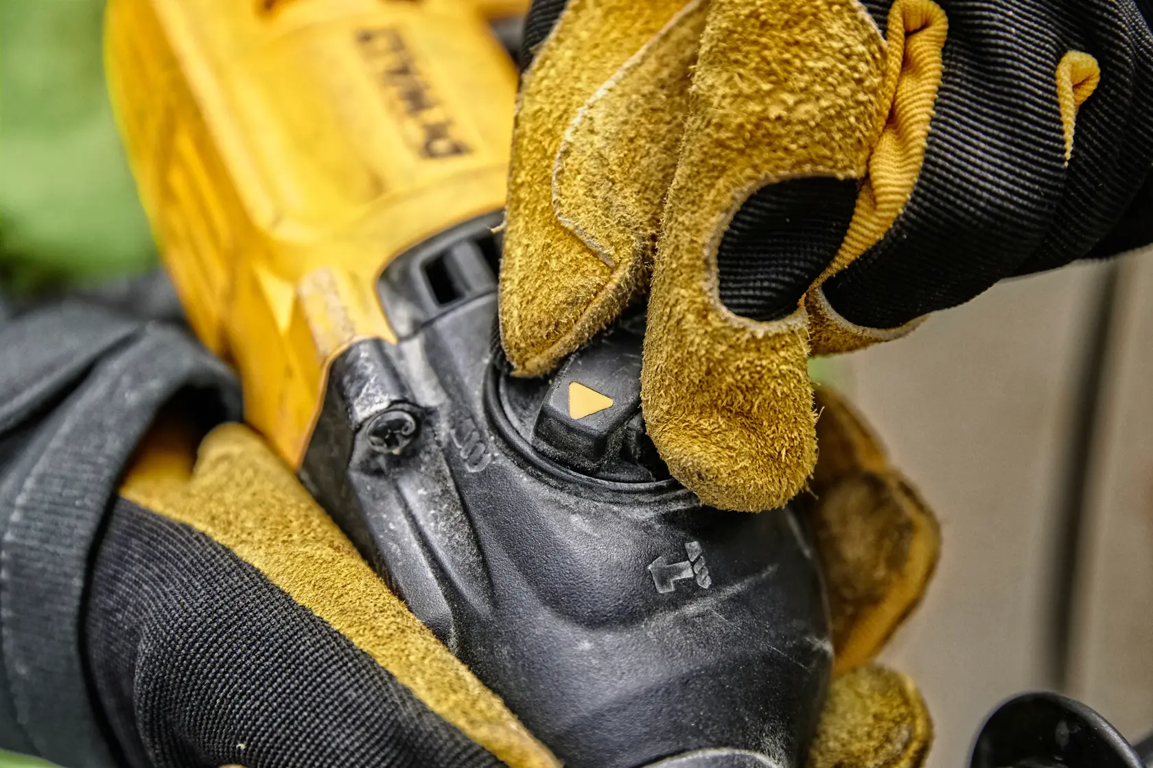 Nahaufnahme einer behandschuhten Hand, die den Moduswahlschalter an einem gelben DEWALT Elektrowerkzeug einstellt.