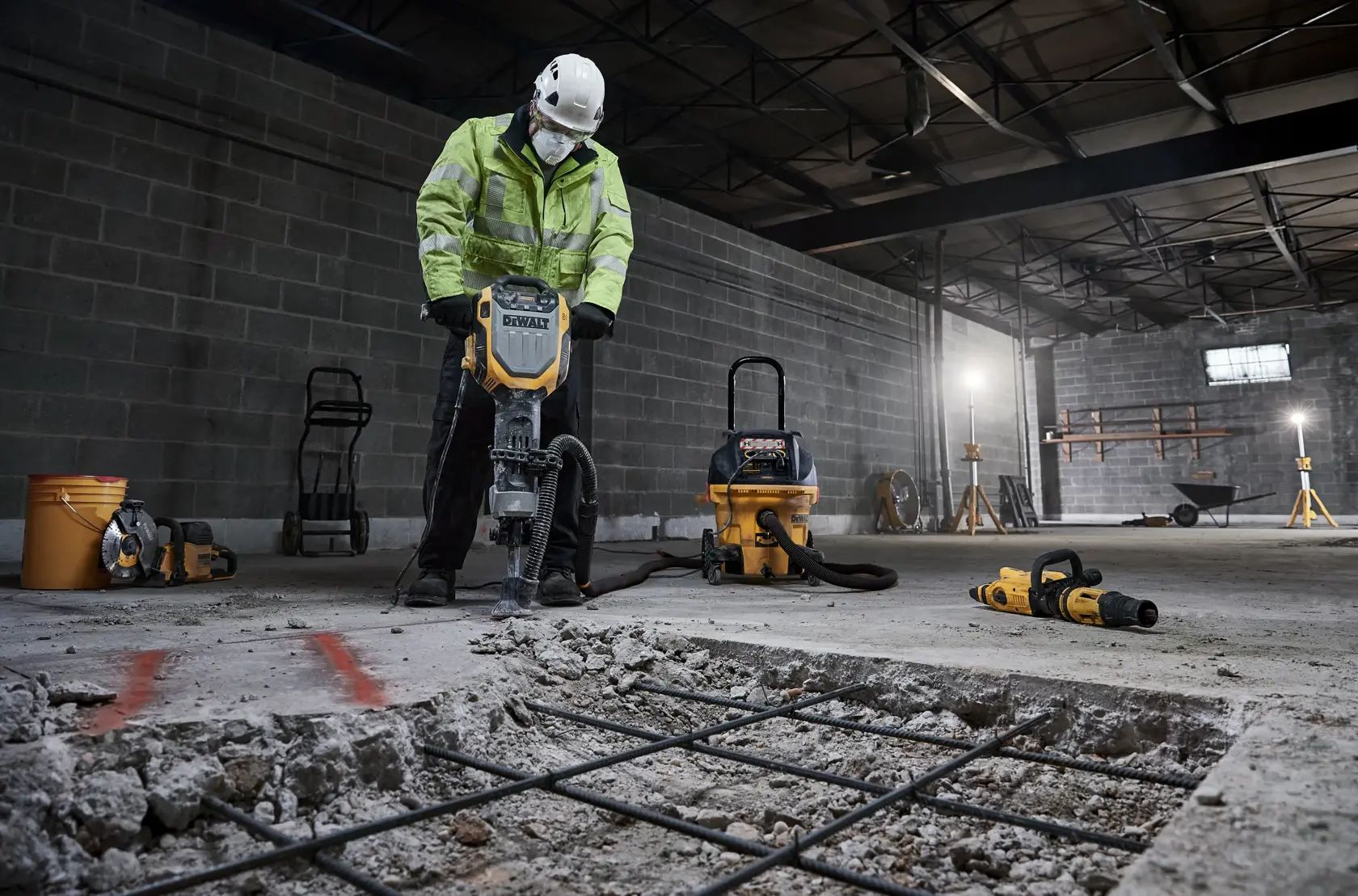 DEWALT D25966, D25966-B2 showcased at work in a construction site, breaking concrete floor with safety gear.