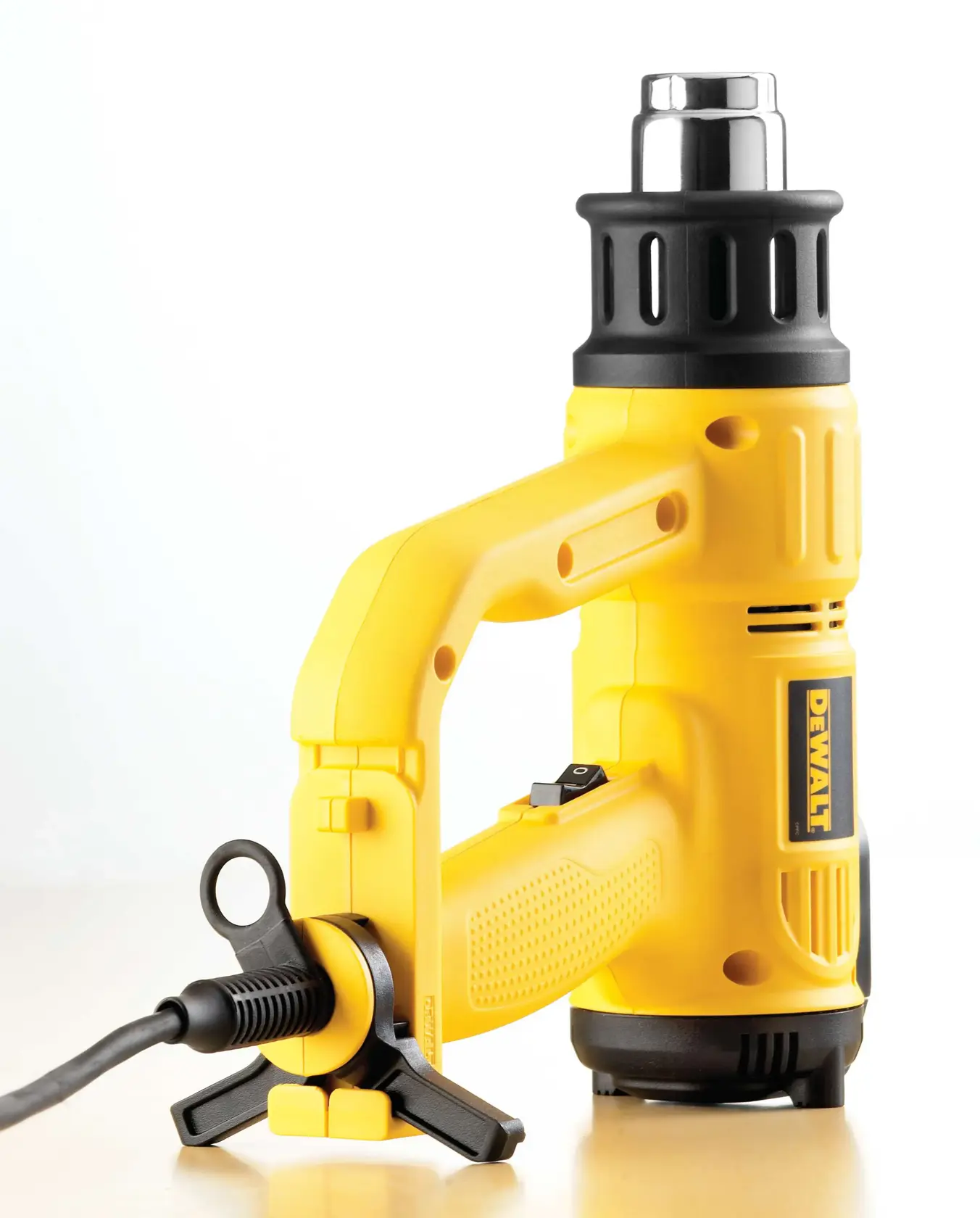 Pistola de calor amarilla DEWALT D26414 con boquilla negra y cable, sobre superficie clara.