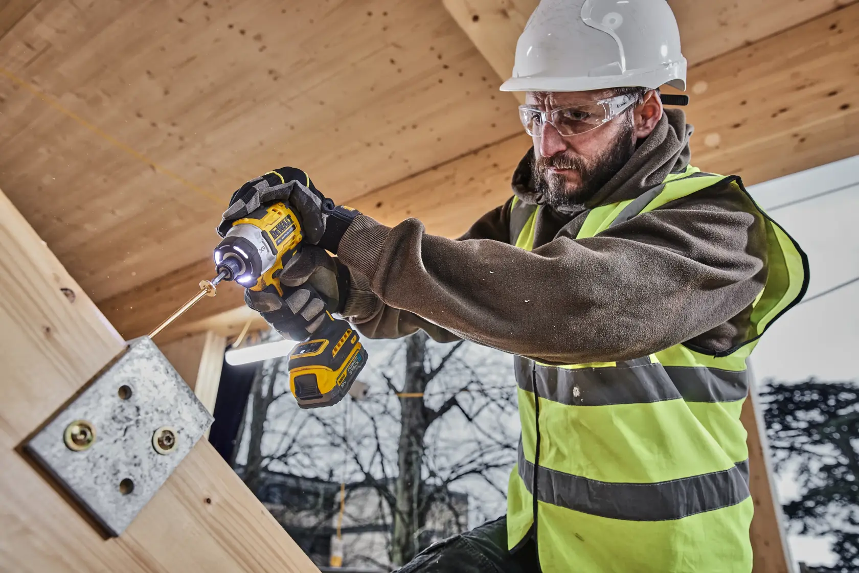 DEWALT 18V cordless impact driver in yellow and black, with brushless motor and PowerStack battery.