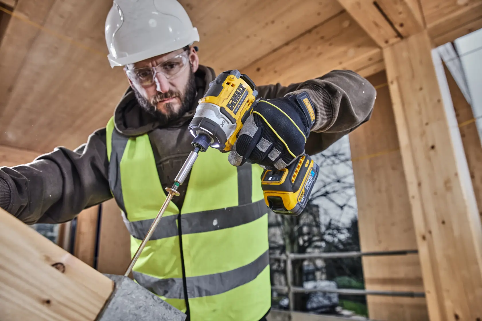 DEWALT DCK2201P1T1-XE, DCF860NT usado por trabajador. Categoría fotografía. Escena de construcción.