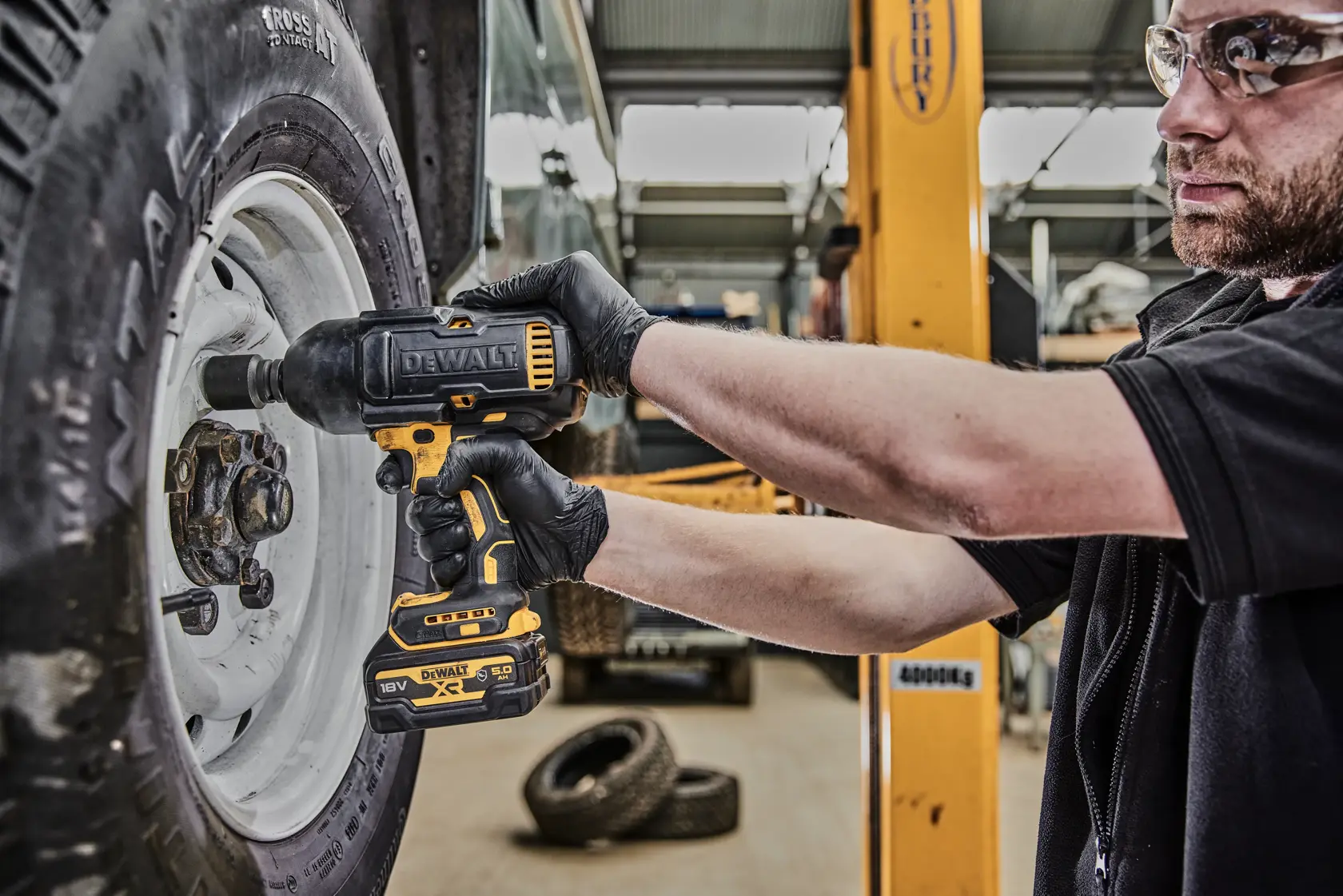 DEWALT DCF900P2G Schlagschrauber zum Festziehen einer Radmutter in einer Kfz-Werkstatt.