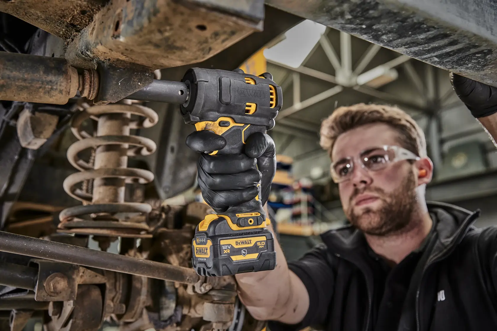 DEWALT DCF901P1G-QW, DCF901P1G Schlagschrauber bei Autoarbeit. Werkzeug in der Hand des Mechanikers.