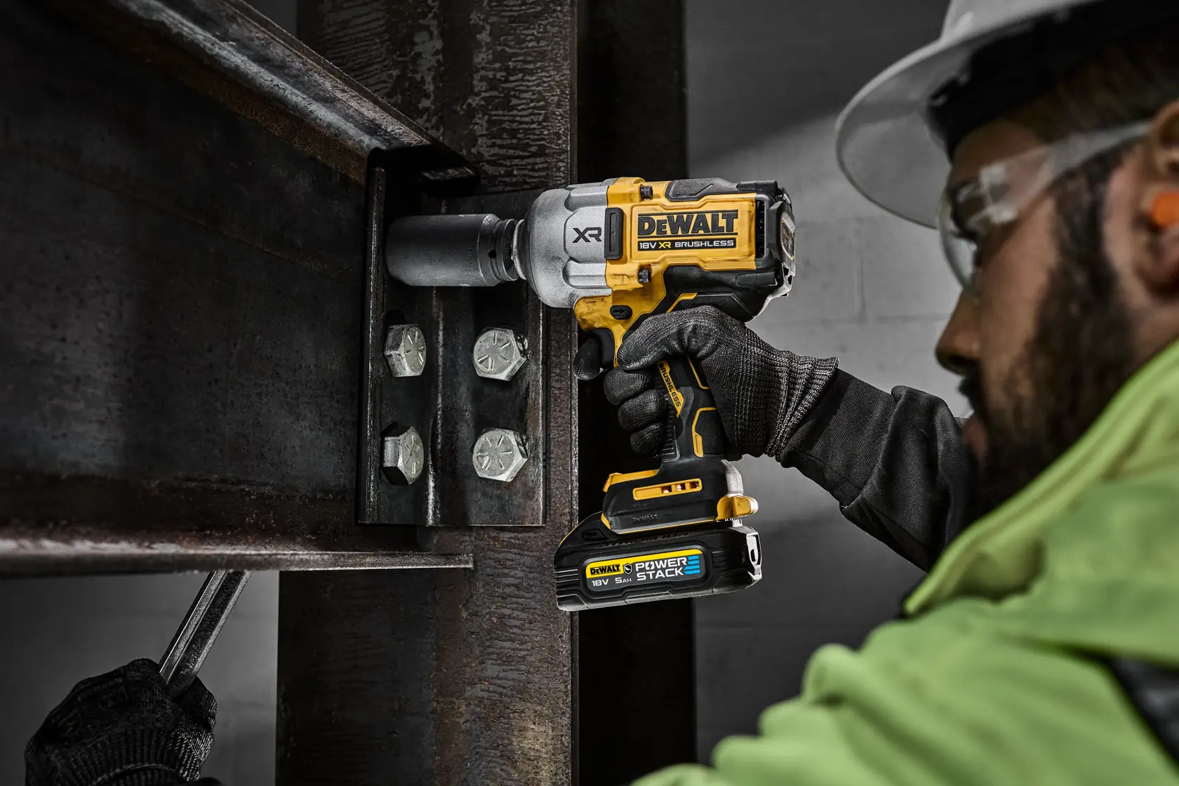Trabajador usa llave de impacto DEWALT inalámbrica en tornillos de viga de acero.