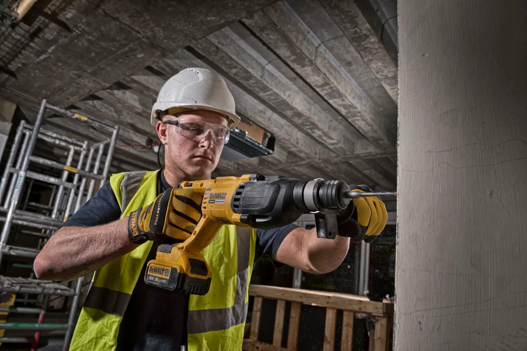 Trabajador usa DEWALT DCH133M1-QW, DCH133M1 martillo rotativo en obra. Categoría fotografía.