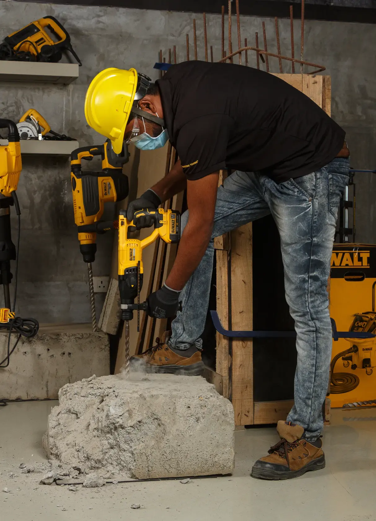 Arbeiter nutzt DEWALT DCH133NT Bohrhammer auf Beton, trägt Schutzkleidung auf Baustelle.