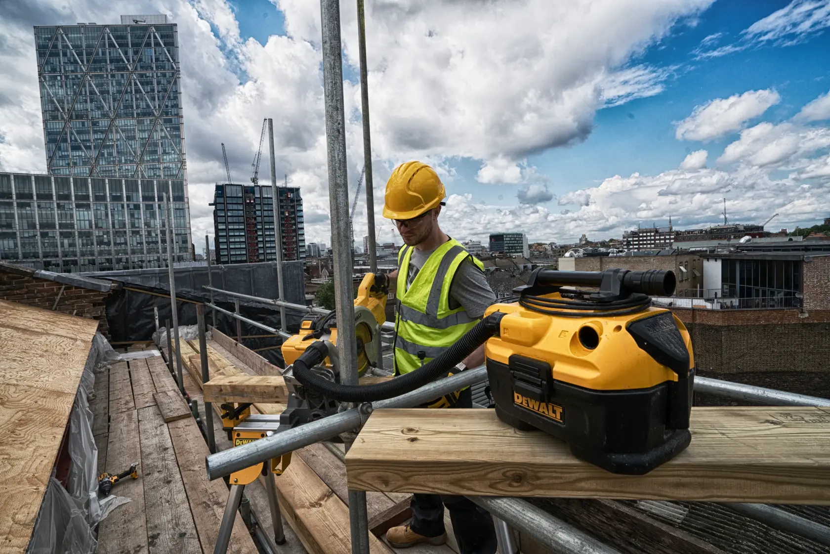 Trabajador usa sierra inalámbrica DEWALT en obra, con casco y chaleco de seguridad.