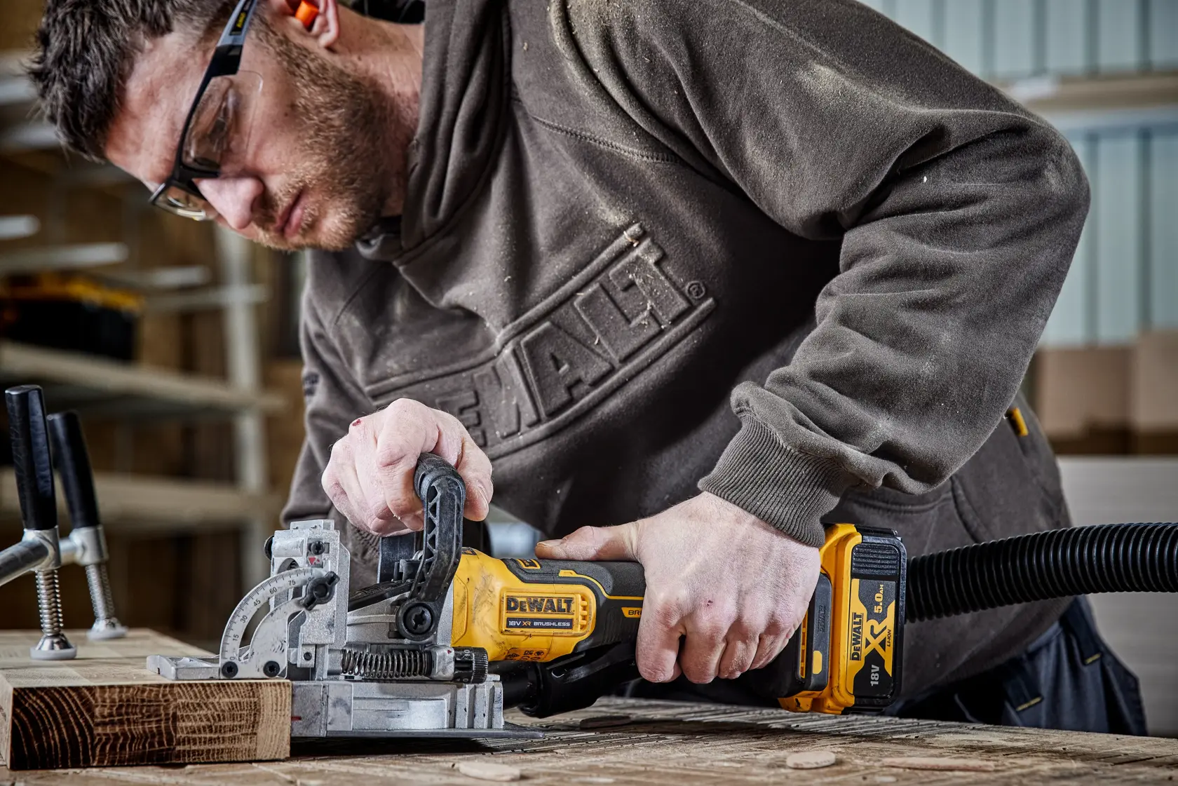 DEWALT DCW682P2-QW, DCW682P2 used for woodworking, person operating tool on wood surface. Photography.