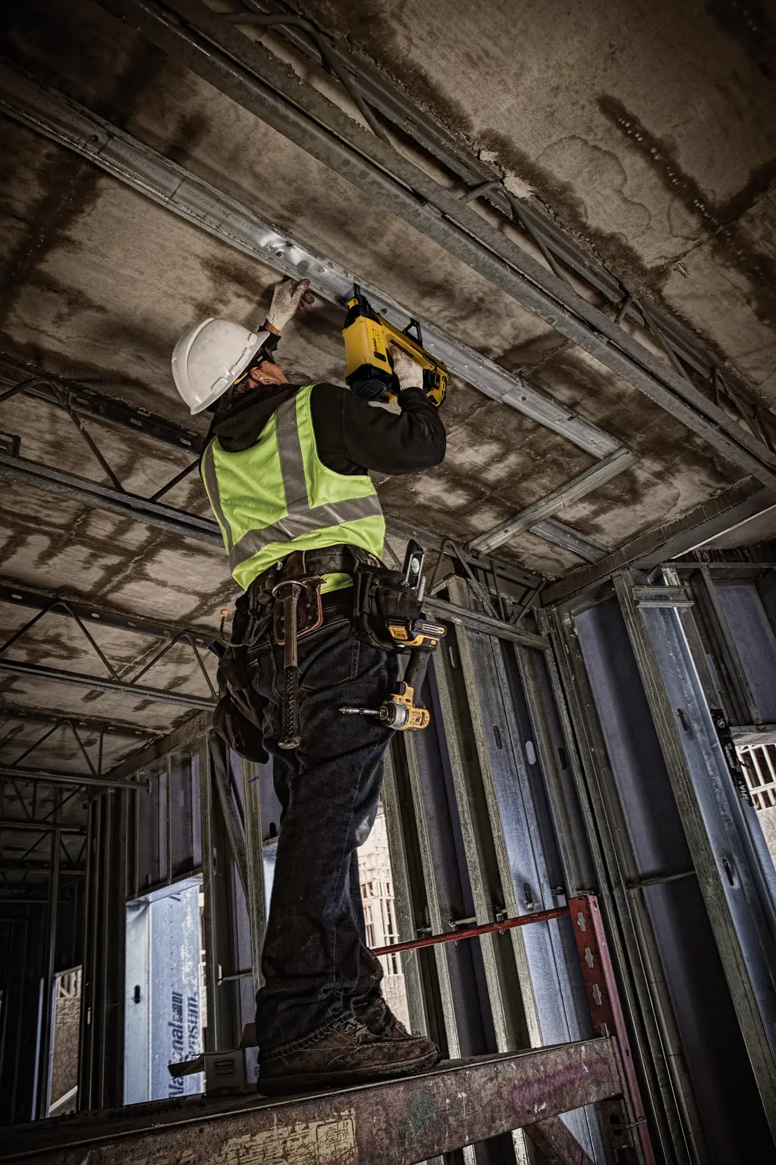 Trabajador usa DEWALT DGN845D1-QW, DGN845D1 en el techo en obra. Categoría fotografía.