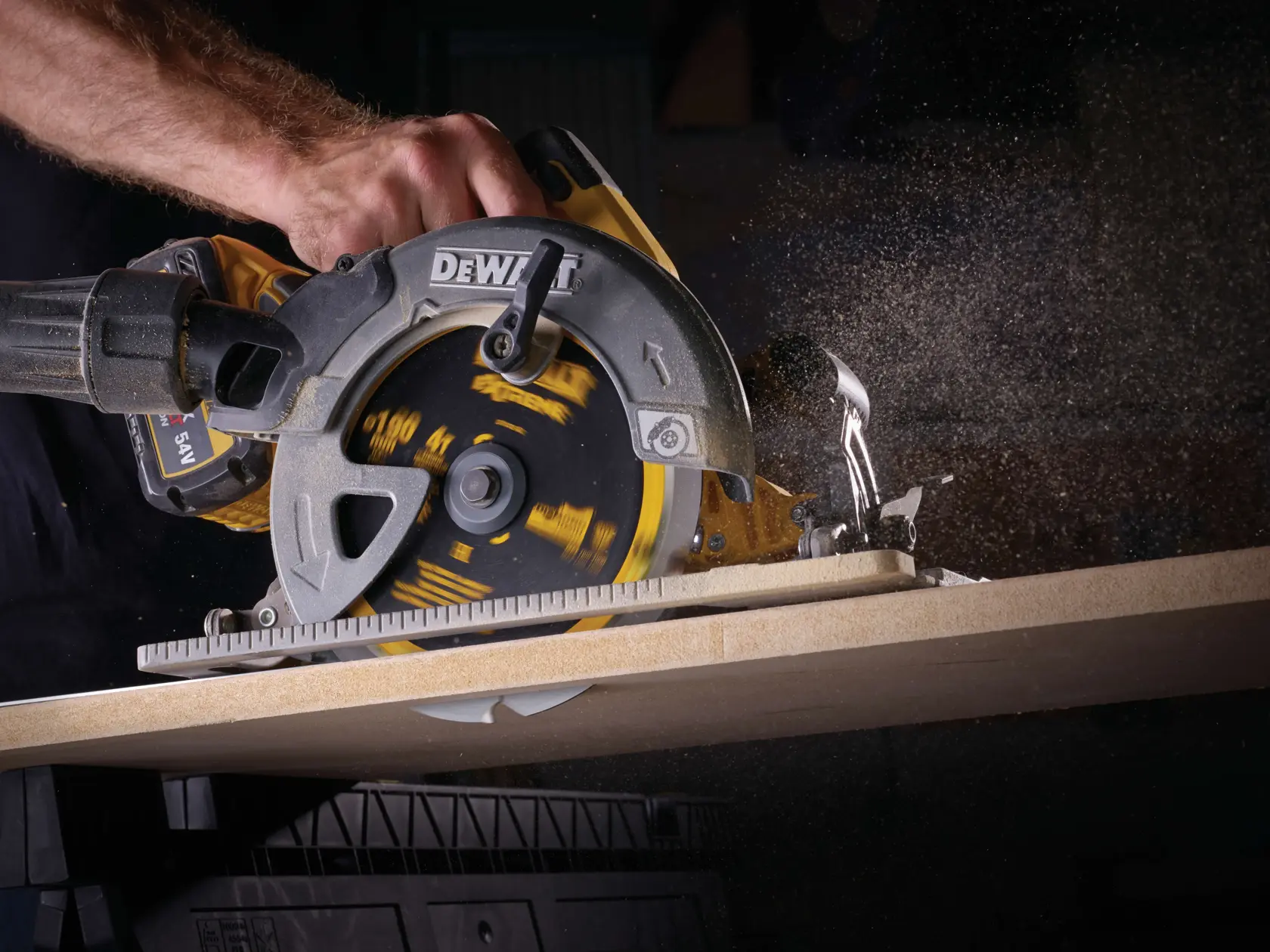 Close-up of DEWALT circular saw cutting wood, with dust flying as the blade rotates.