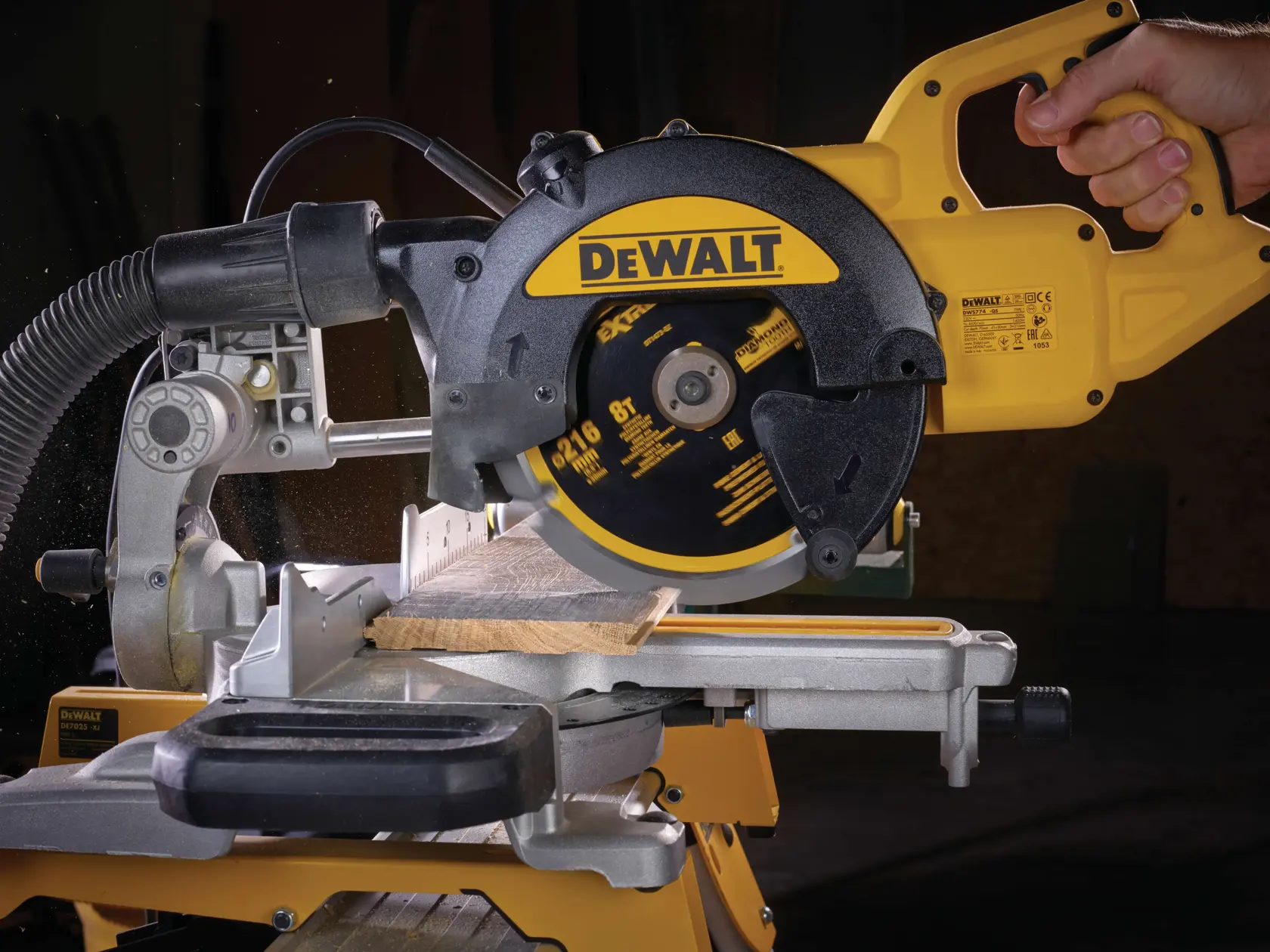 DEWALT circular saw cutting wood on a miter saw stand, operated by a hand in a workshop setting.