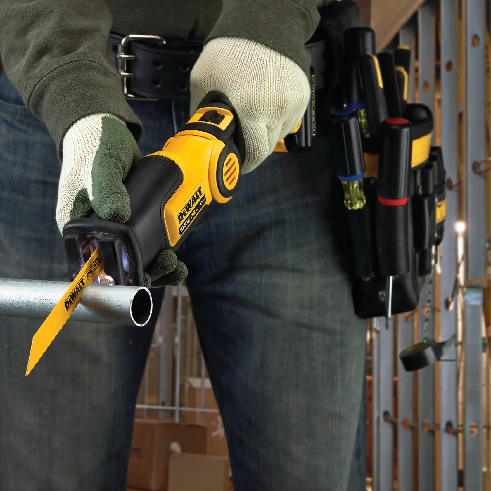 Person uses DEWALT reciprocating saw to cut a metal pipe; tool belt and gloves visible.