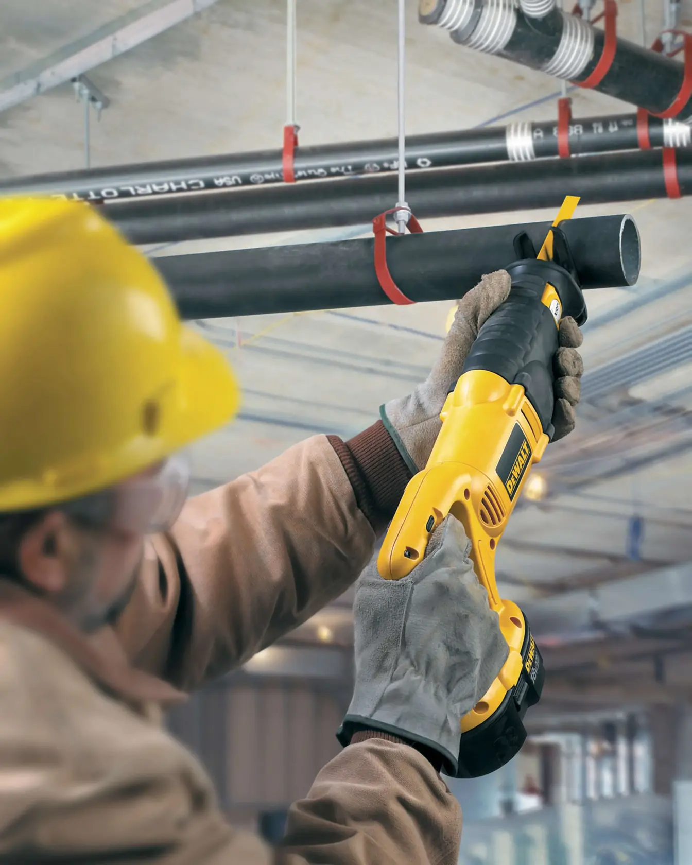 Photo of DEWALT reciprocating saw in use, cutting pipe. SKUs DT2361-QZ, DT2361. Construction context.
