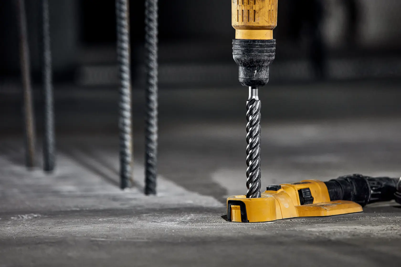 Photo of DEWALT DT60829 concrete drill bit, attached to drill, working on concrete floor.