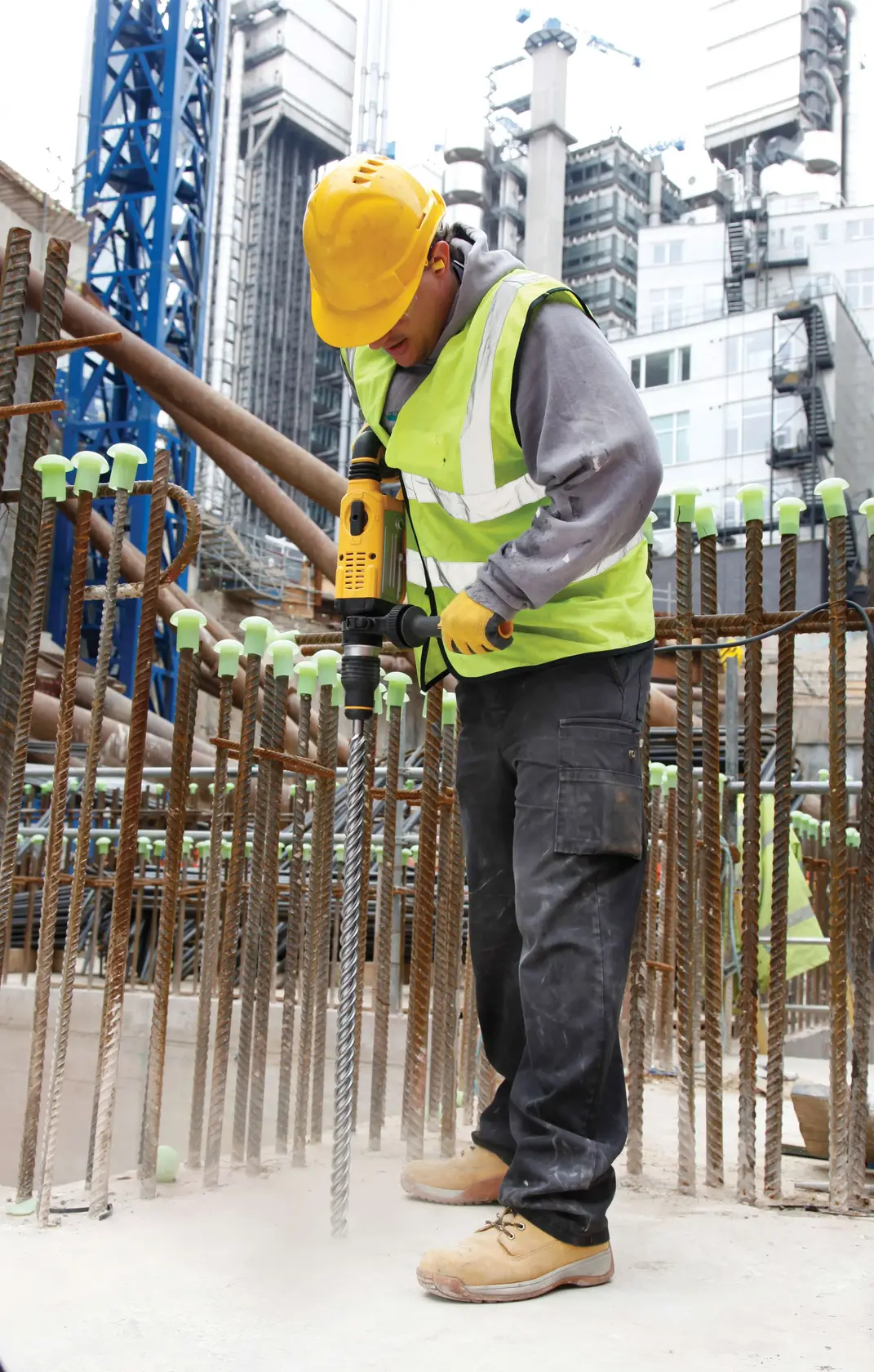 DEWALT DT60836 rotary hammer used by worker in safety vest and helmet on construction site.
