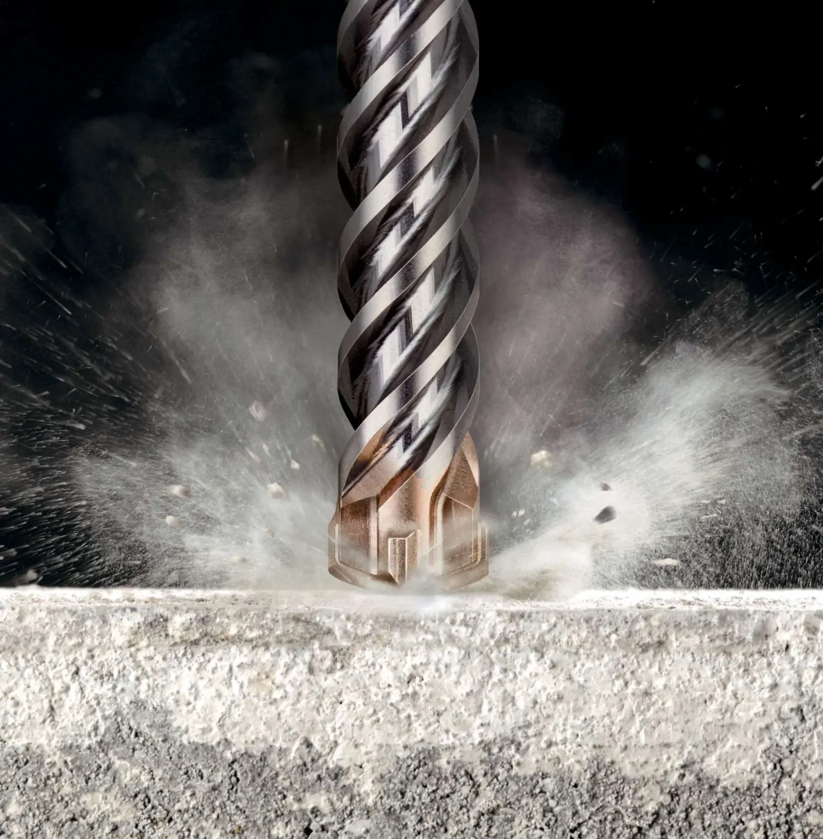 Photo of DEWALT DT60839 rotary hammer drill bit tip impacting concrete, close-up with dust and debris particles.