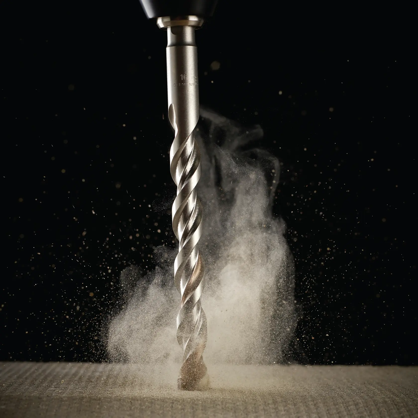 DEWALT drill bit drilling into material, dust rising, close-up against dark background.