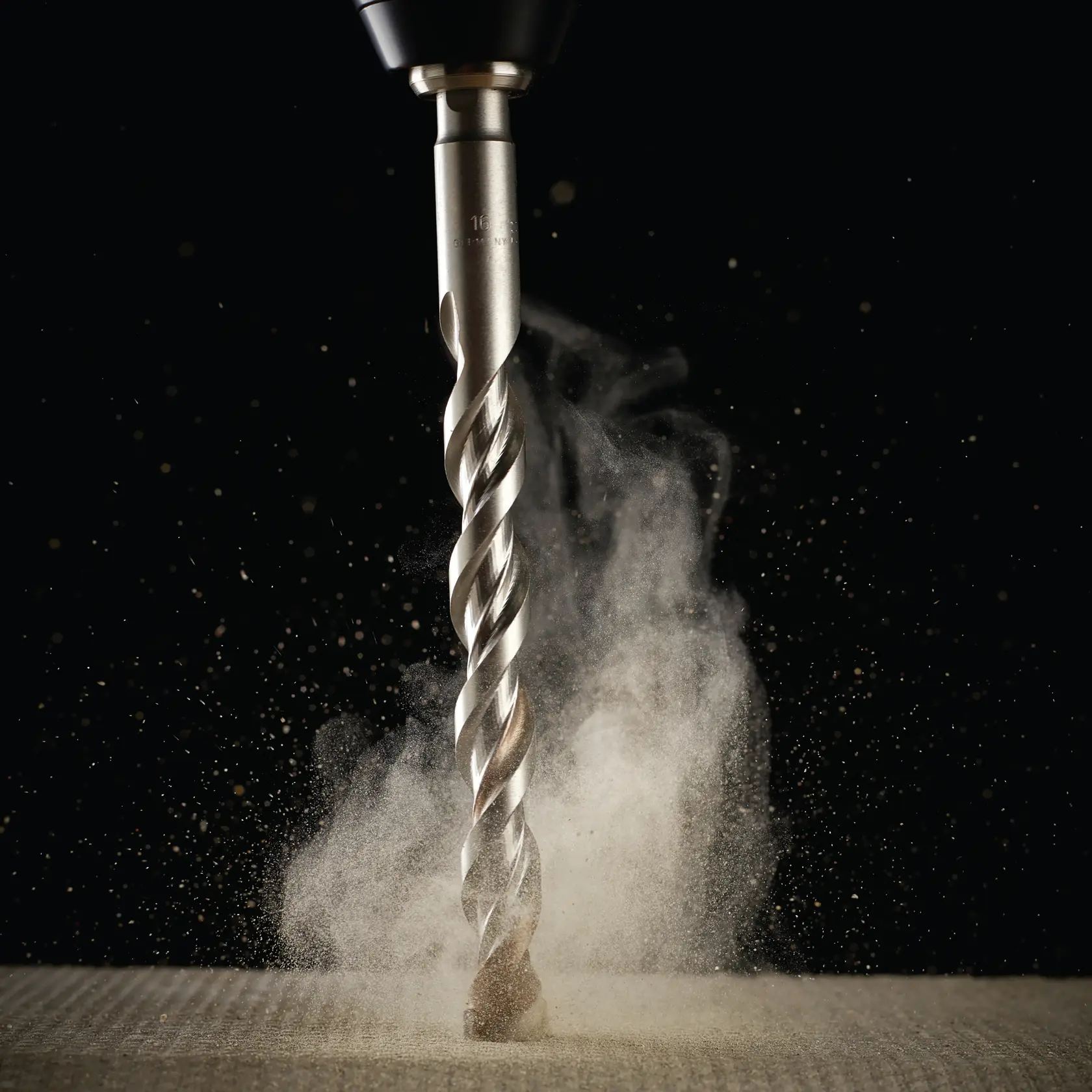 Close-up of a DEWALT drill bit cutting material, with dust particles rising on a dark background.