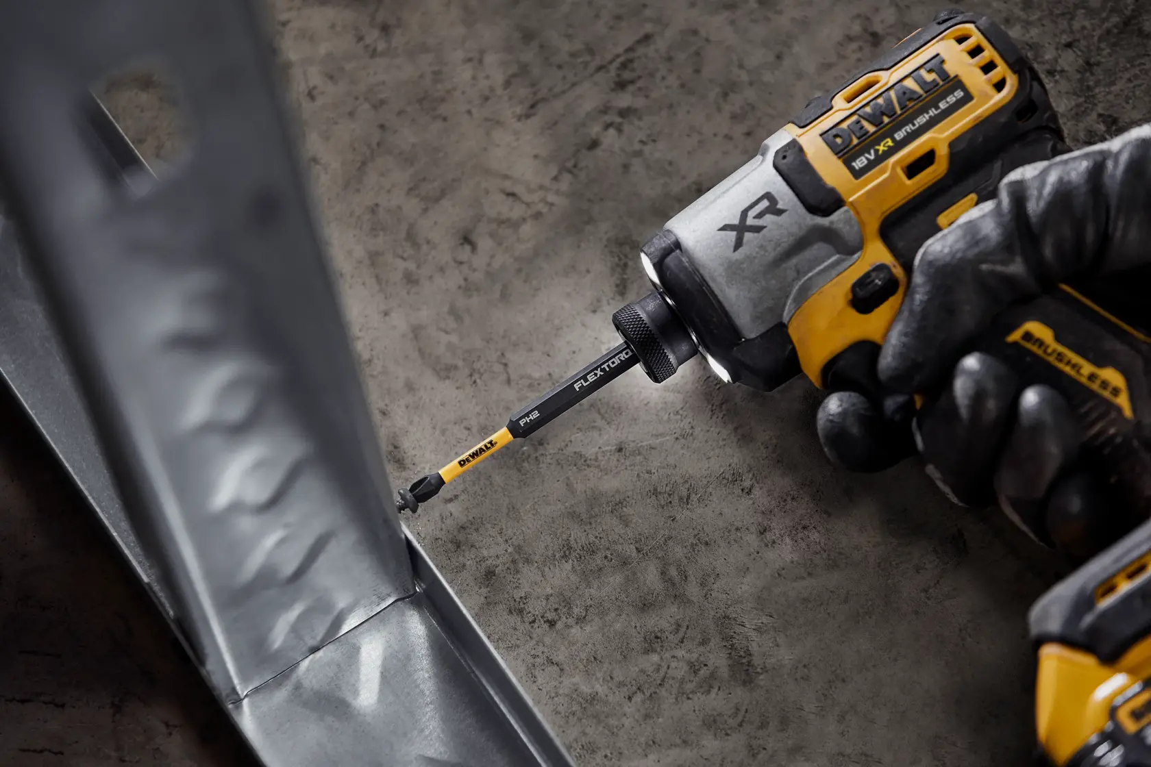 DEWALT impact driver with FlexTorq bit being used to fasten a screw into a metal frame.