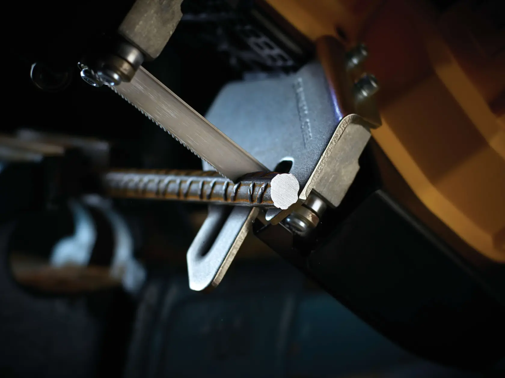 Close-up of a DEWALT saw blade cutting through a metal rebar with precision.