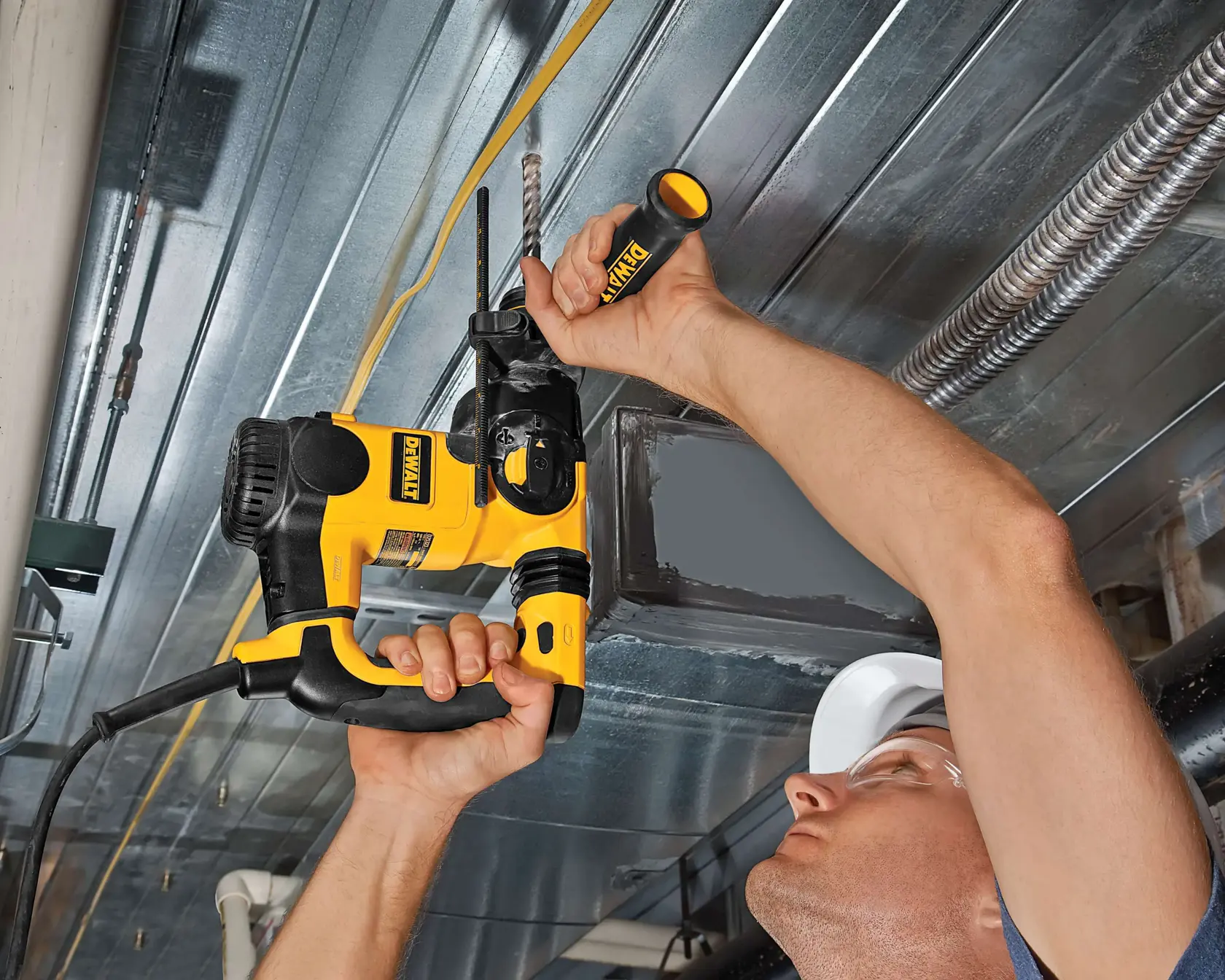 Photo of DEWALT DT9549 drill in use on ceiling metal, handheld, visible yellow-black design.