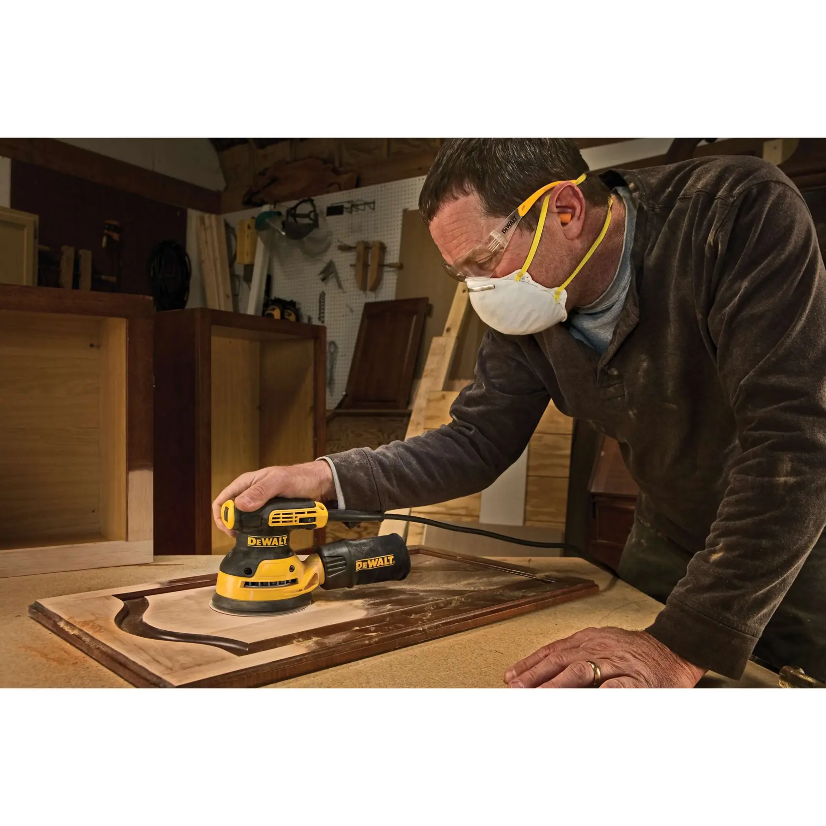 Ein DEWALT Exzenterschleifer mit Staubbeutel und schwarzer Tragetasche, jeweils mit DEWALT-Logo versehen.