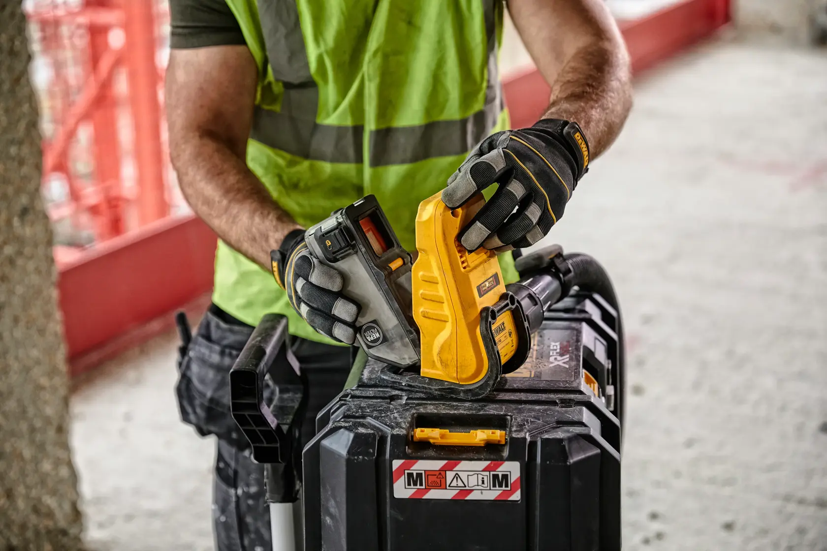 Vue de face d'un évacuateur de boîte à poussière DEWALT DWH079D, un accessoire de photographie avec un corps jaune, des accents noirs et des étiquettes d'avertissement.