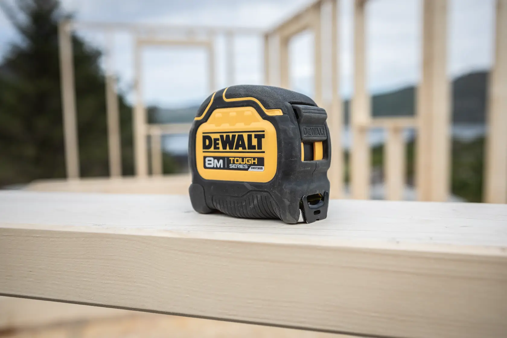 Cinta métrica DEWALT 8 metros Tough Series sobre viga de madera en obra.