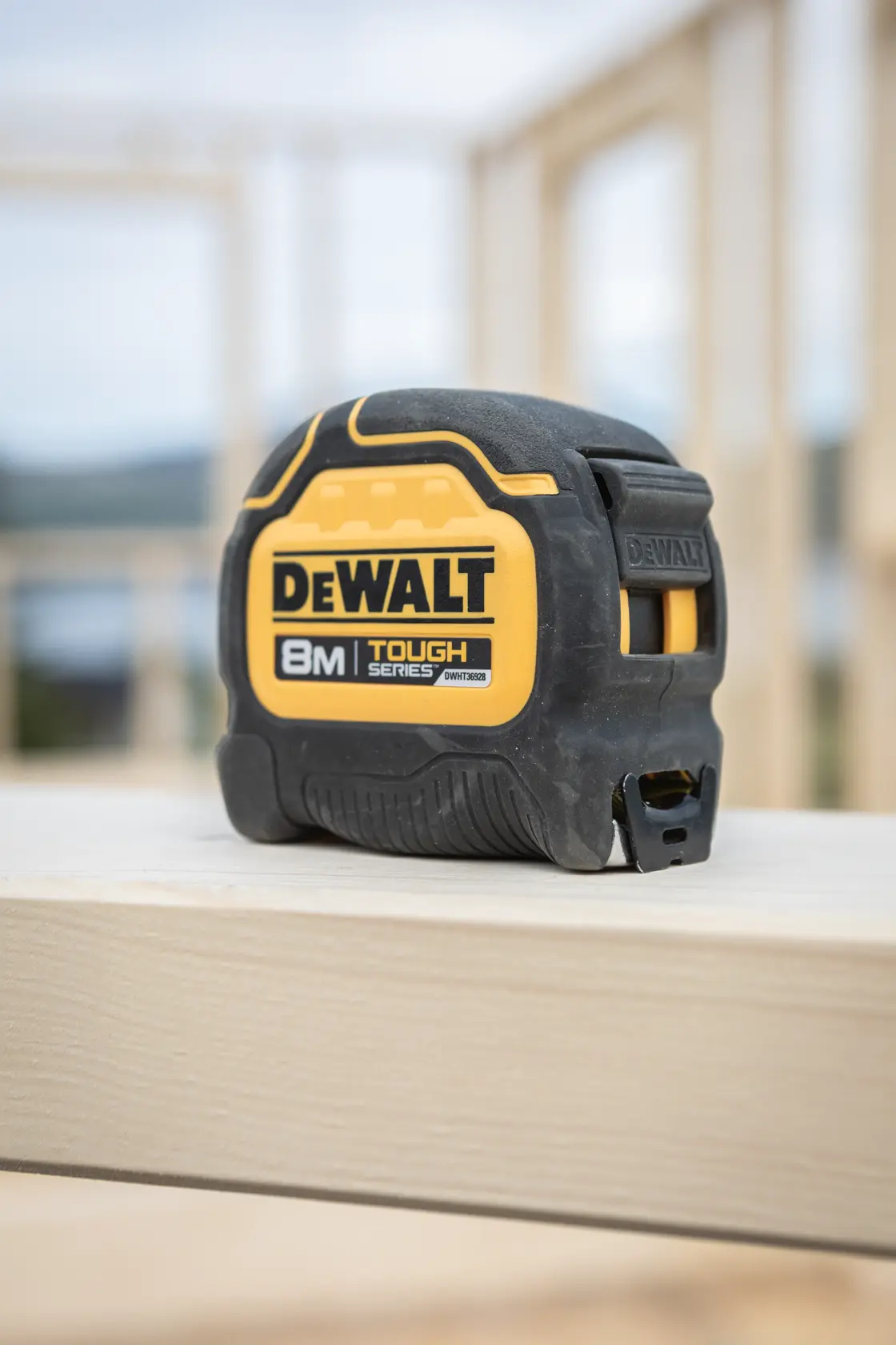 Cinta métrica DEWALT 8m Tough Series sobre una tabla de madera en obra.