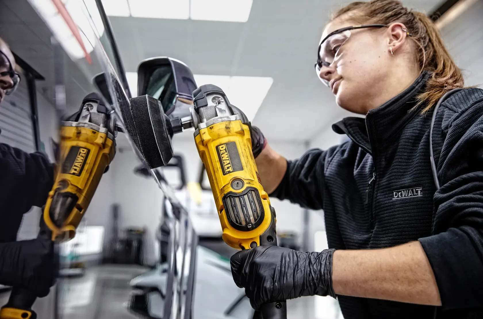 Una persona utiliza una pulidora DEWALT DWP849X sobre la superficie negra de un automóvil. La herramienta es amarilla y negra, y el texto en la imagen destaca el excelente equilibrio de peso y potencia para un mejor rendimiento de la herramienta.